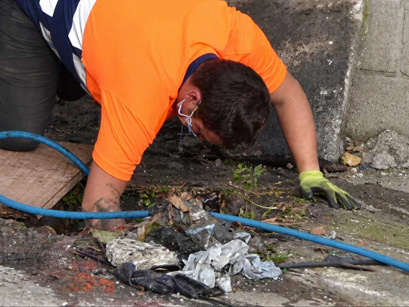 Operario de Desatascos Nago limpiando una arqueta a mano